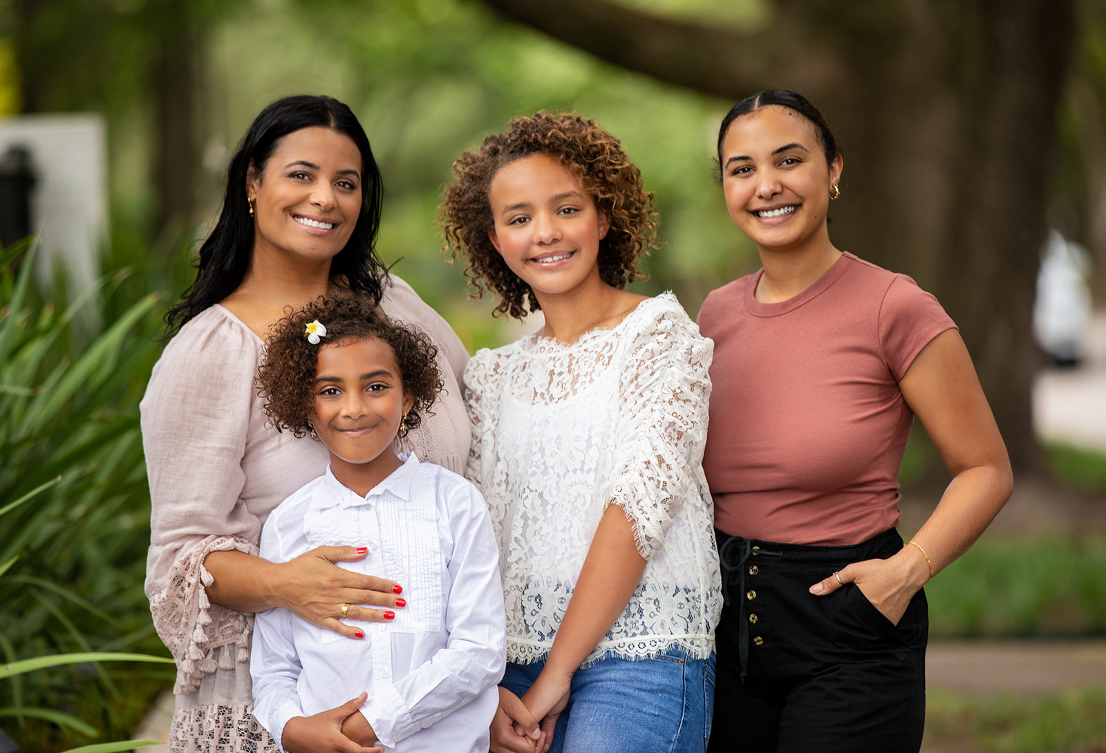 Family of four smiling outdoors during mini photography sessions Houston in Rice Village