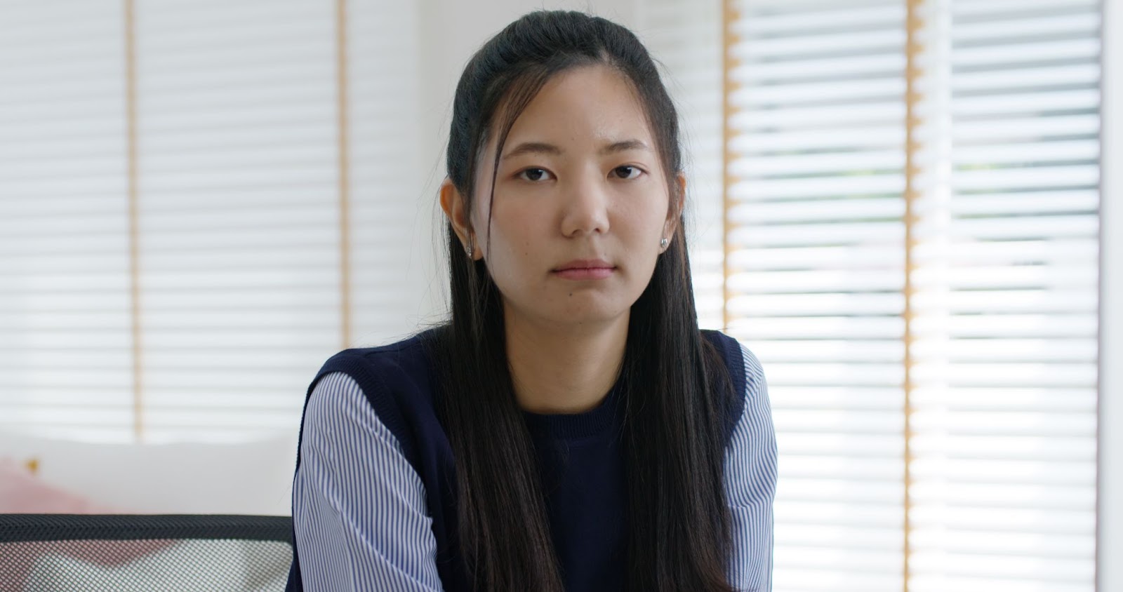 a woman posing in an office with an unhappy face