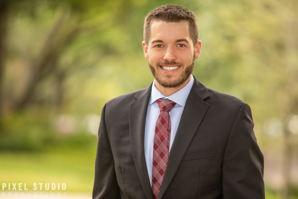Corporate professional headshot of a business professional in a suit outdoors