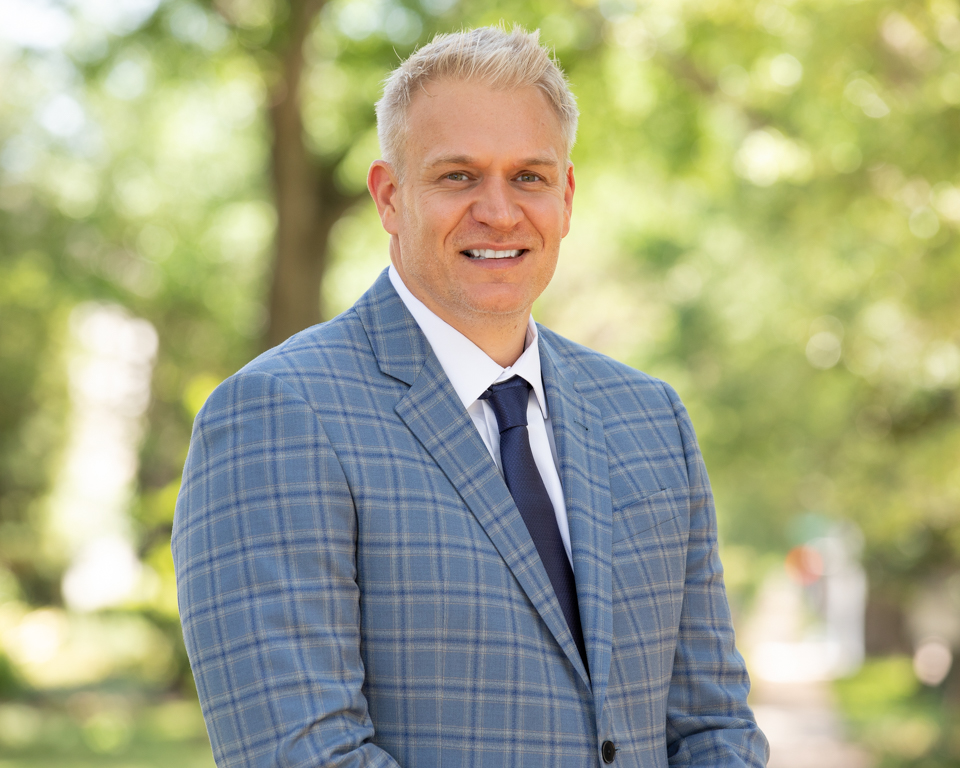 Professional outdoor executive headshot with natural expression