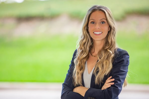 Confident woman in business attire smiling outdoors in Houston.