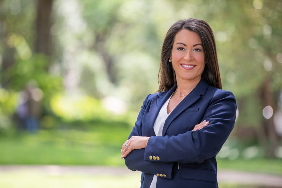 Confident businesswoman smiling outdoors for professional headshot.