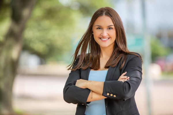 Confident businesswoman smiling outdoors for professional headshot.