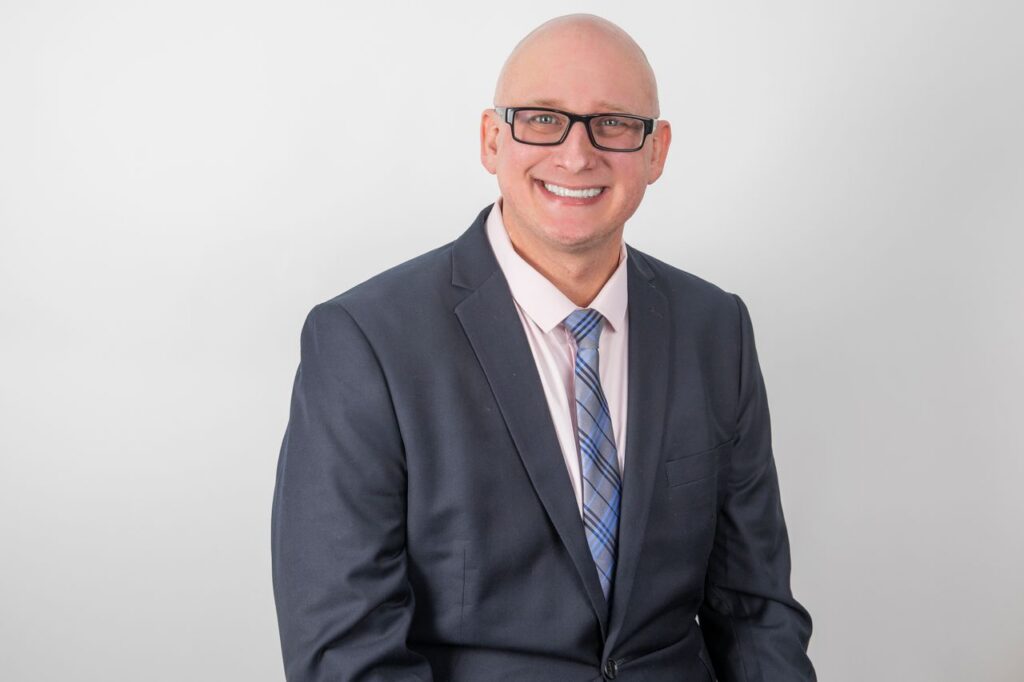 CPA headshot in Houston, man in navy suit and tie on studio backdrop