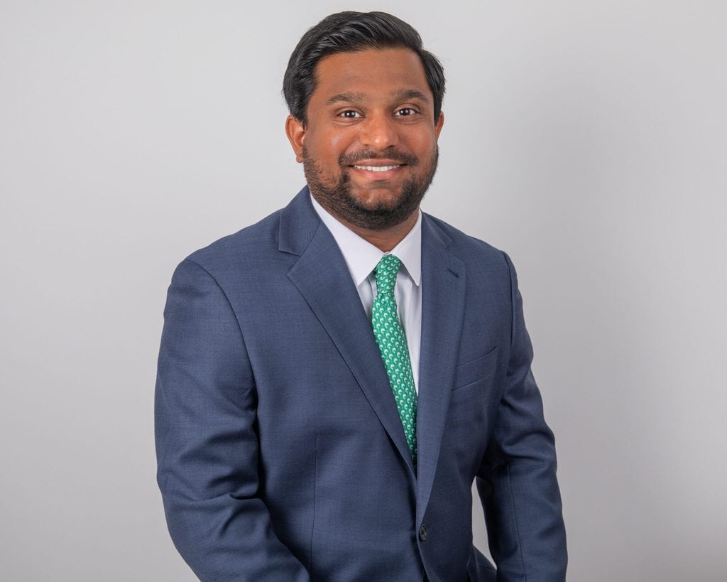 Businessman in blue suit smiling for professional headshot in Houston.