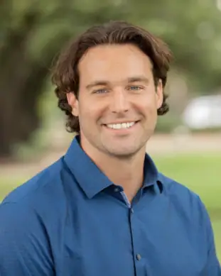 Ken, Pixel Studio Productions videographer, outdoor portrait in a blue button-up shirt