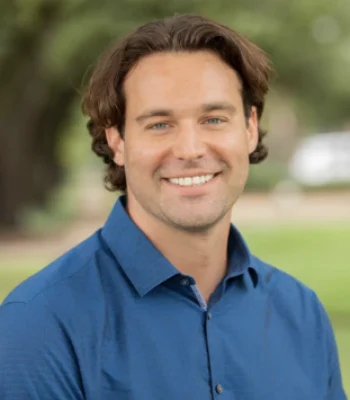 Ken, Pixel Studio Productions videographer, outdoor portrait in a blue button-up shirt