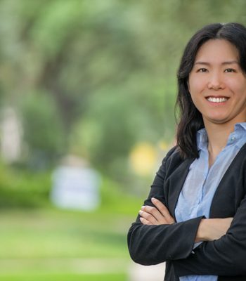 Susan, Pixel Studio Productions team member, outdoor portrait in a black blazer and light blue shirt with arms crossed